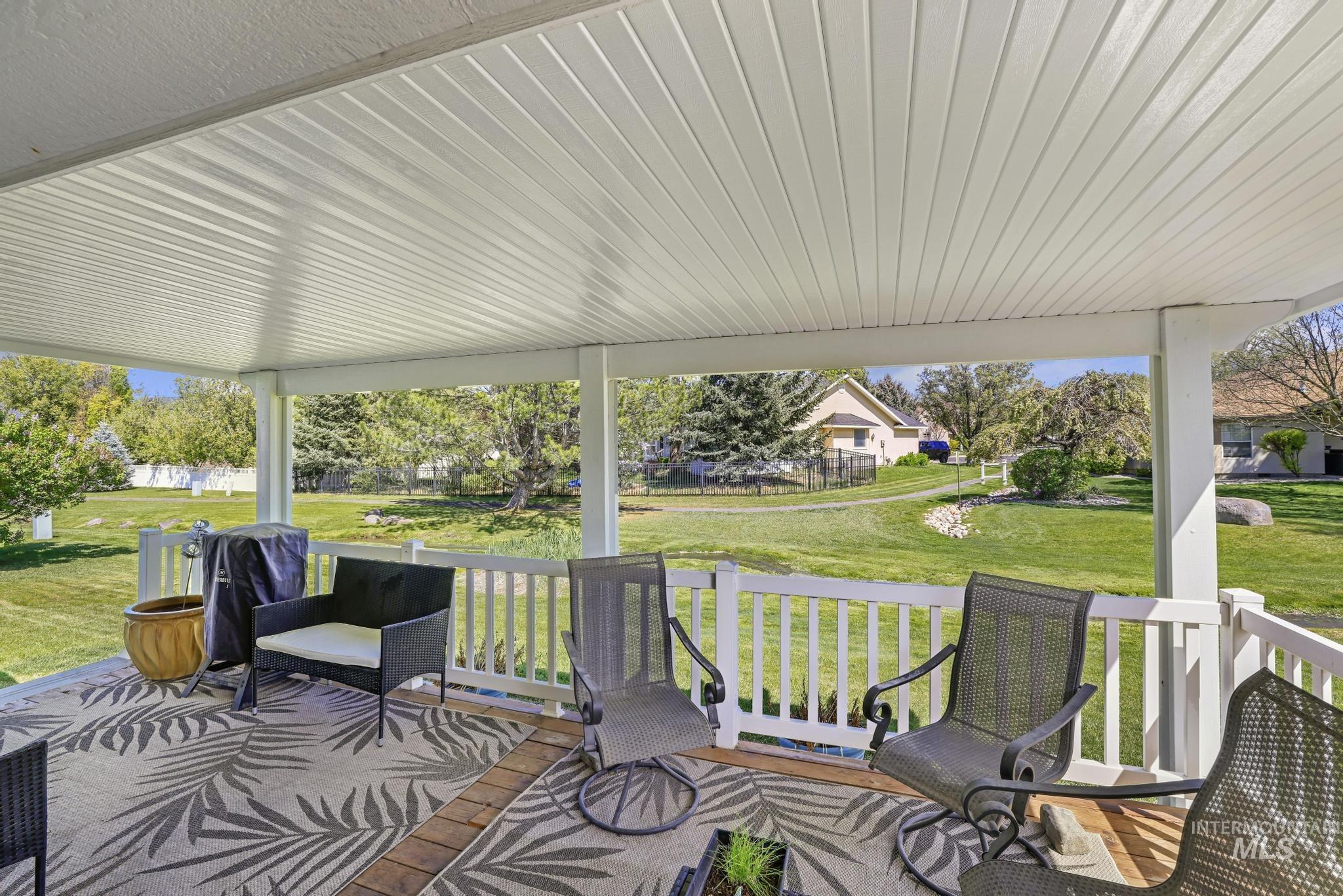 1558 Brookside Loop Twin Falls, ID 83301 - Photo 32 of 47 Spacious covered patio with a white slatted ceiling, white railing, and wood-finish flooring with brick accents
