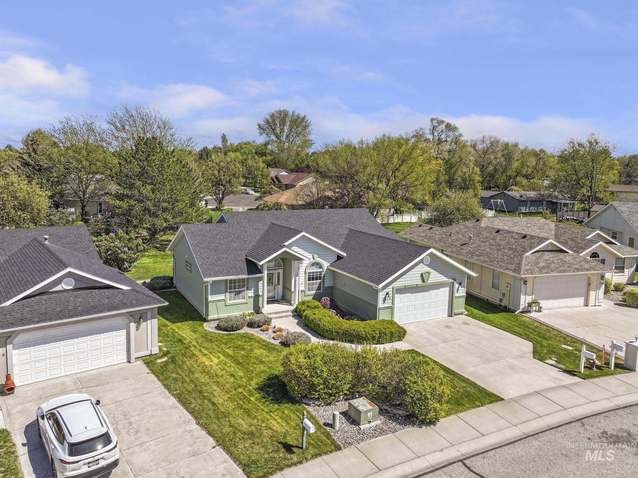 1558 Brookside Loop Twin Falls, ID 83301 - Photo 33 of 47 Single-story residence featuring a light green exterior with white trim, a dark shingle roof, and an attached two-car garage