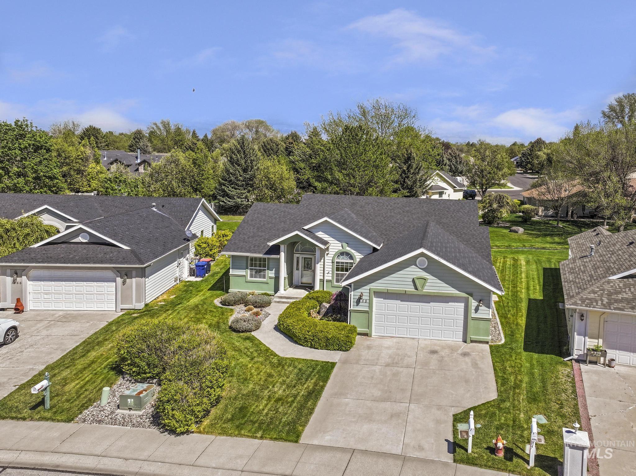 1558 Brookside Loop Twin Falls, ID 83301 - Photo 35 of 47 Light green facade with white trim, a dark shingle roof, and an attached two-car garage