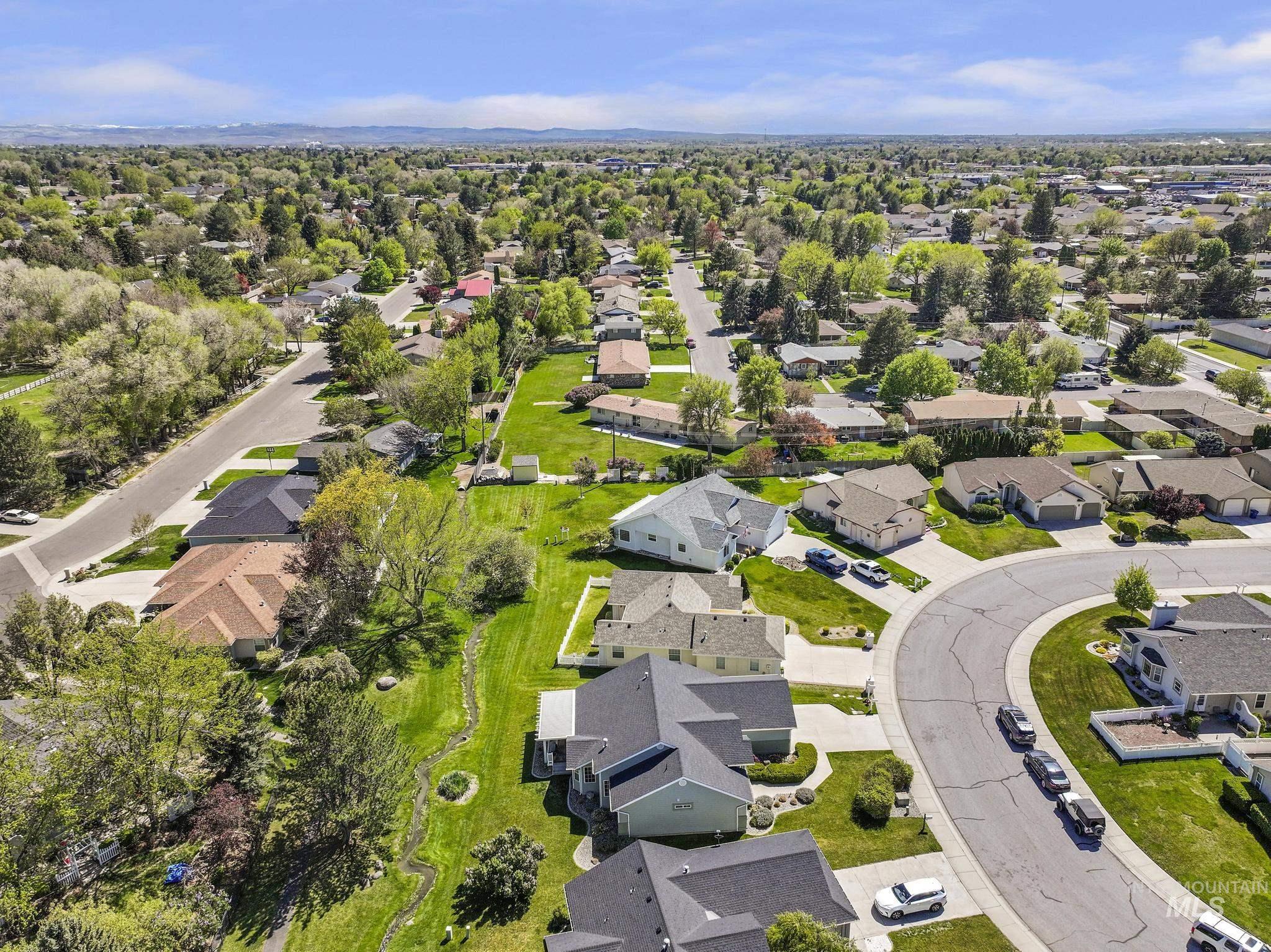 1558 Brookside Loop Twin Falls, ID 83301 - Photo 43 of 47 Overhead aerial showcasing residential properties with a mountainous backdrop, mature trees, and a curvilinear street layout