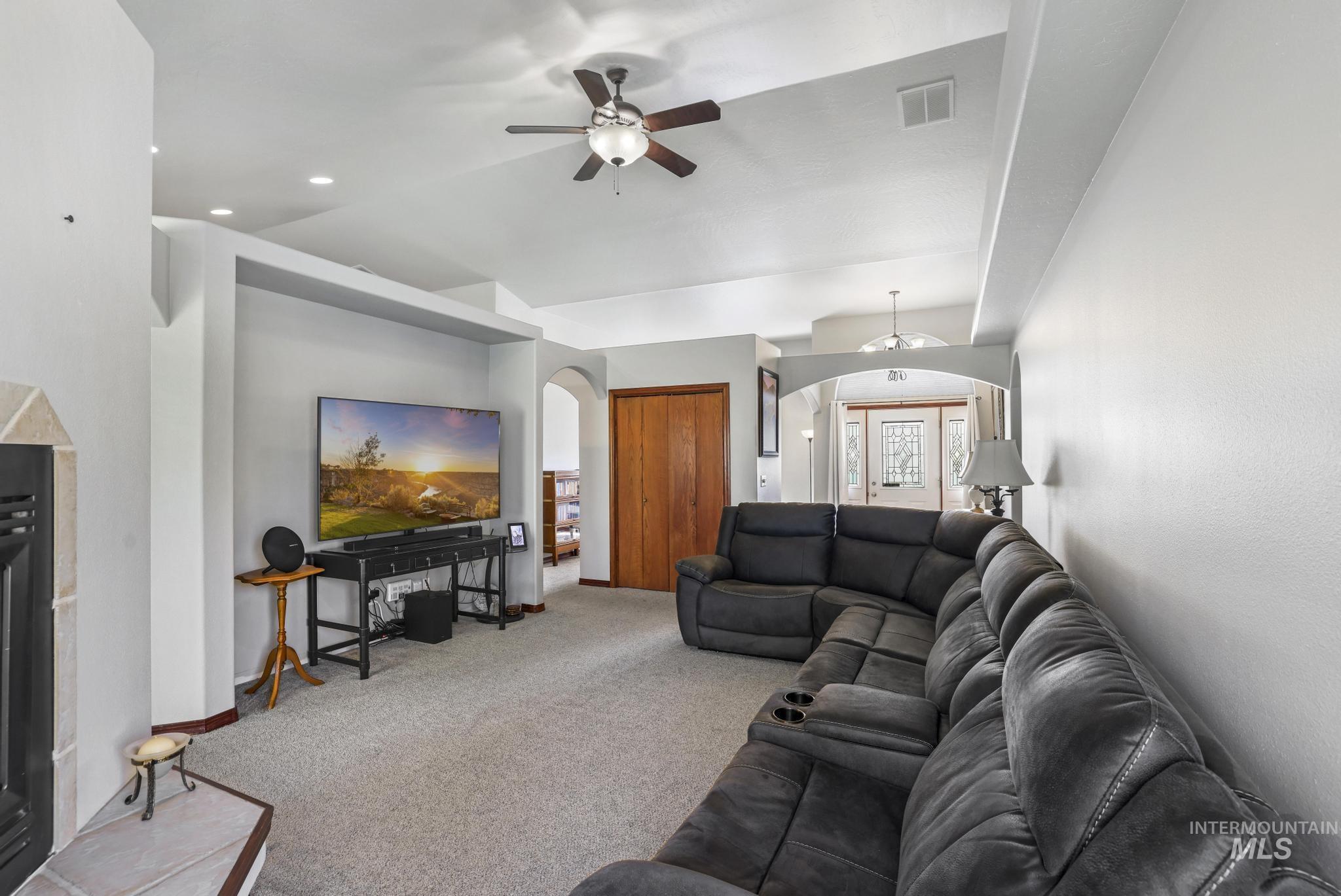 1558 Brookside Loop Twin Falls, ID 83301 - Photo 8 of 47 Living area featuring vaulted ceilings, a ceiling fan with integrated lighting, recessed lighting, and a fireplace with a tiled hearth and surround