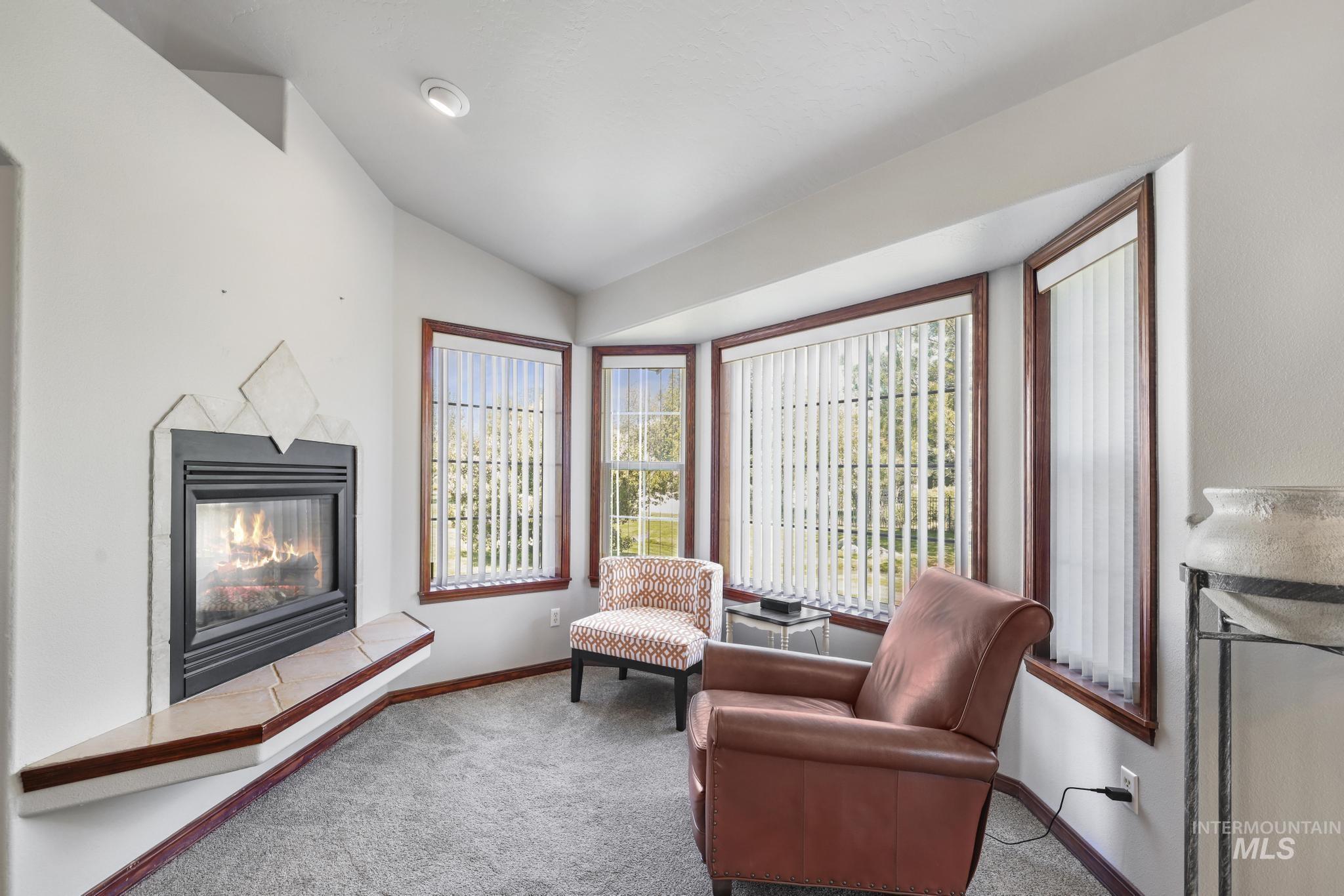 1558 Brookside Loop Twin Falls, ID 83301 - Photo 10 of 47 Bay window with vertical blinds, a fireplace with a tiled hearth, and recessed lighting