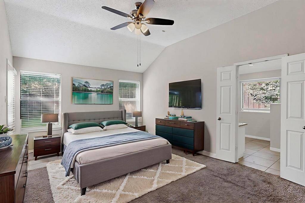 820 Charter Oak Street Allen, TX 75002 - Photo 23 of 37 Bedroom with light colored carpet, vaulted ceiling, a ceiling fan, a textured ceiling, and light tile patterned floors