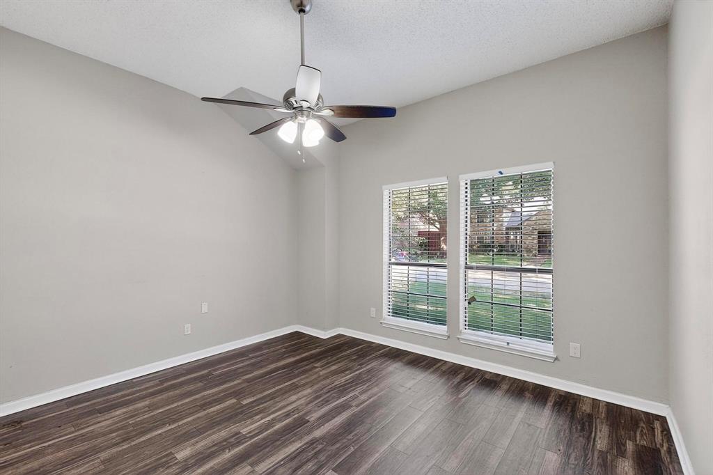 820 Charter Oak Street Allen, TX 75002 - Photo 27 of 37 Empty room with dark wood-type flooring, a textured ceiling, a ceiling fan, and lofted ceiling