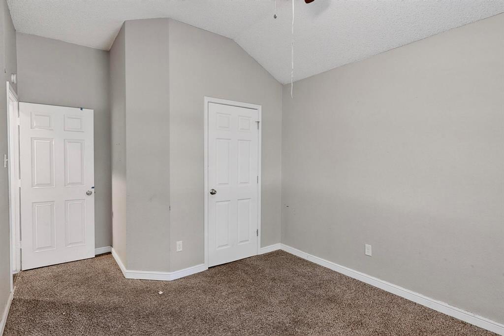 820 Charter Oak Street Allen, TX 75002 - Photo 33 of 37 Unfurnished bedroom featuring carpet, lofted ceiling, and a textured ceiling