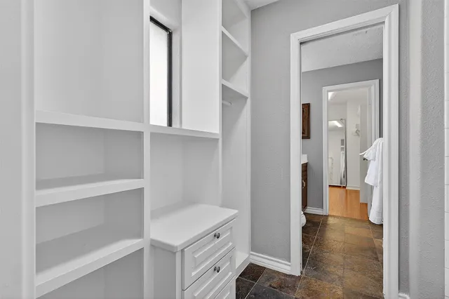 an empty room with windows and ceiling fan