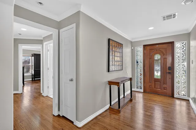 a view of a hallway with wooden floor and windows