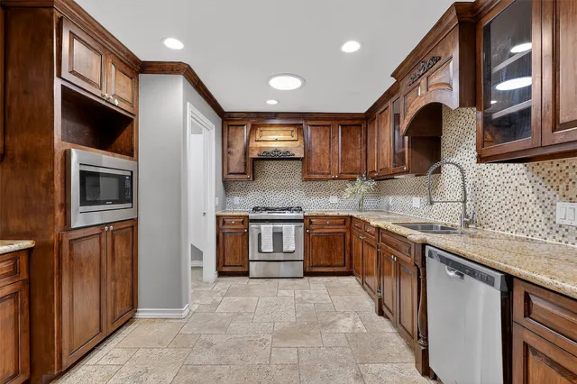 a kitchen with stainless steel appliances granite countertop a stove sink and cabinets