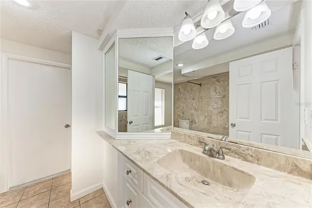 a bathroom with a granite countertop sink a large mirror and a shower