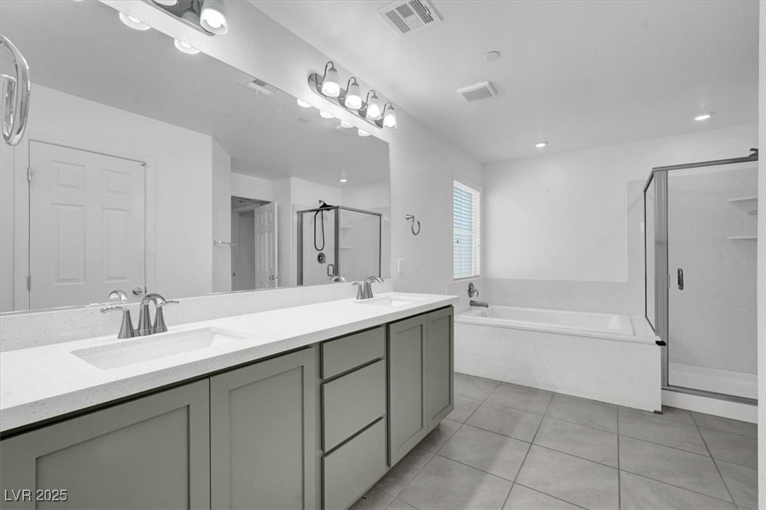 8033 Skye Foxx Street Las Vegas, NV 89166 - Photo 12 of 25 Full bathroom featuring a stall shower, double vanity, light tile patterned flooring, and a bath