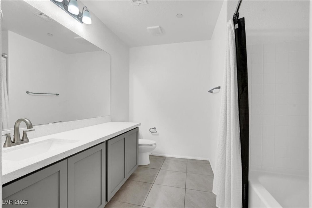 8033 Skye Foxx Street Las Vegas, NV 89166 - Photo 14 of 25 Full bathroom with vanity, light tile patterned floors, and shower / bath combo with shower curtain