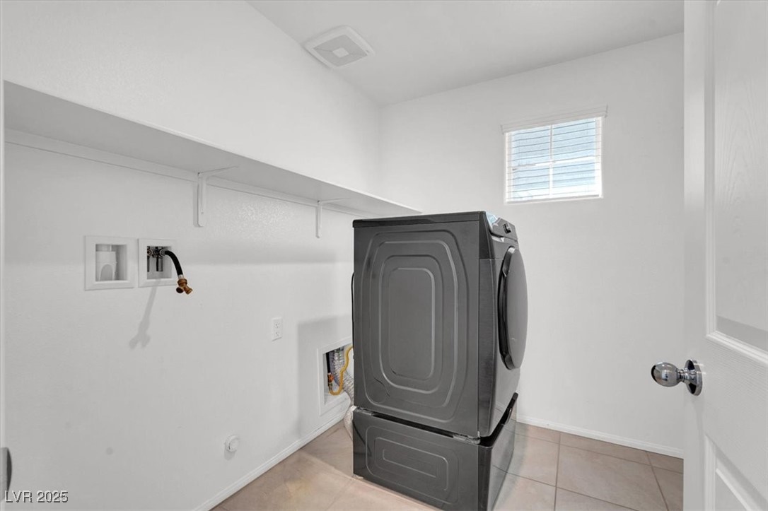 8033 Skye Foxx Street Las Vegas, NV 89166 - Photo 16 of 25 Laundry room with washer / clothes dryer and light tile patterned floors