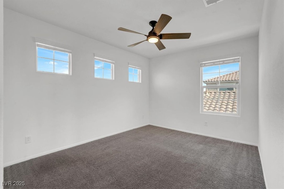 8033 Skye Foxx Street Las Vegas, NV 89166 - Photo 21 of 25 Unfurnished room with dark carpet and a ceiling fan