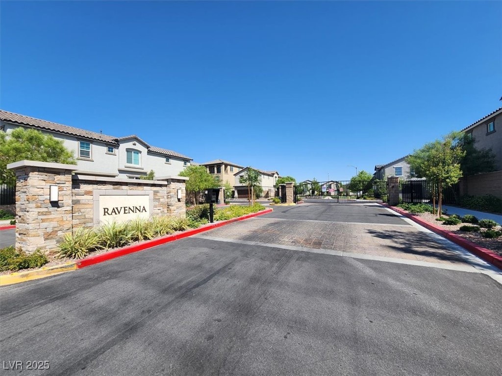 8033 Skye Foxx Street Las Vegas, NV 89166 - Photo 24 of 25 View of asphalt road with curbs, a gated entry, a residential view, and a gate