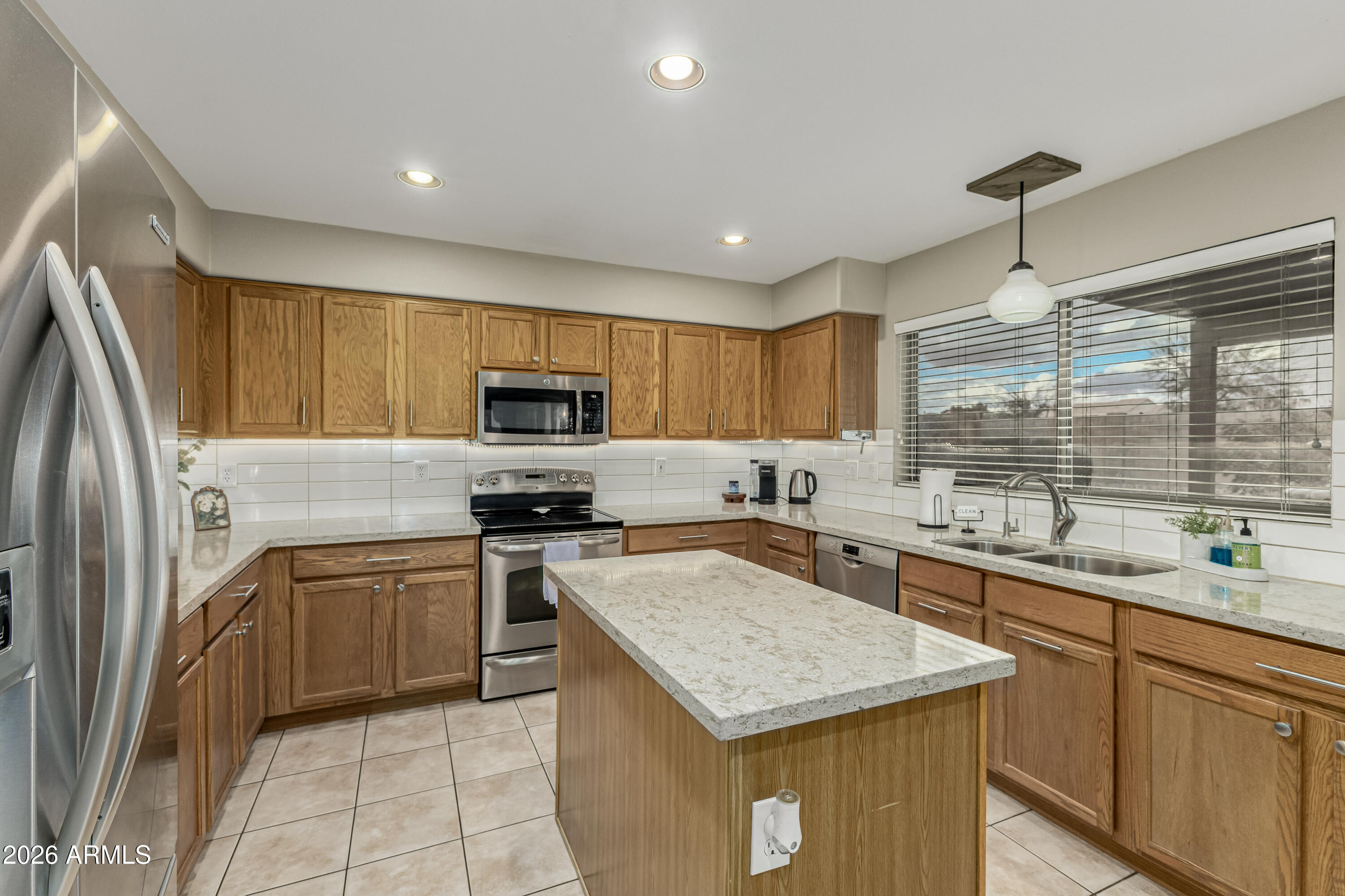 1737 South Talbot Mesa, AZ 85209 - Photo 12 of 35 a kitchen with a sink a center island a stove a refrigerator cabinets and a window