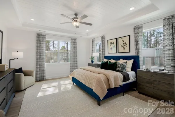 a living room with furniture a large window and wooden floor