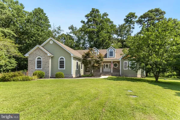 a front view of a house with a yard and trees