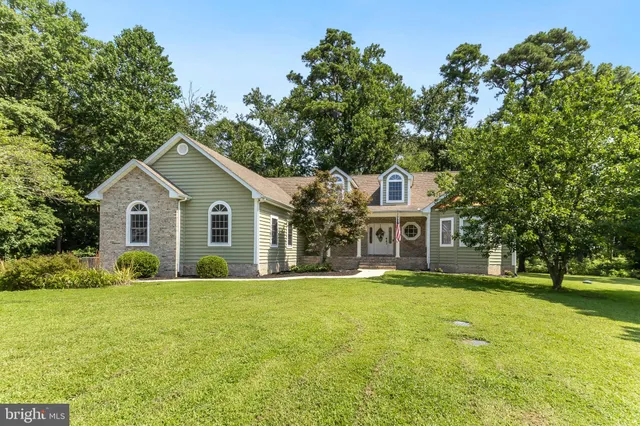 a front view of a house with a yard and trees