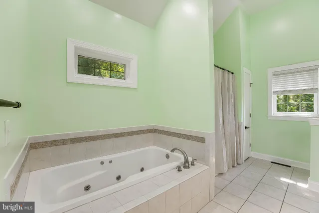 a bedroom with a bed chandelier and a window