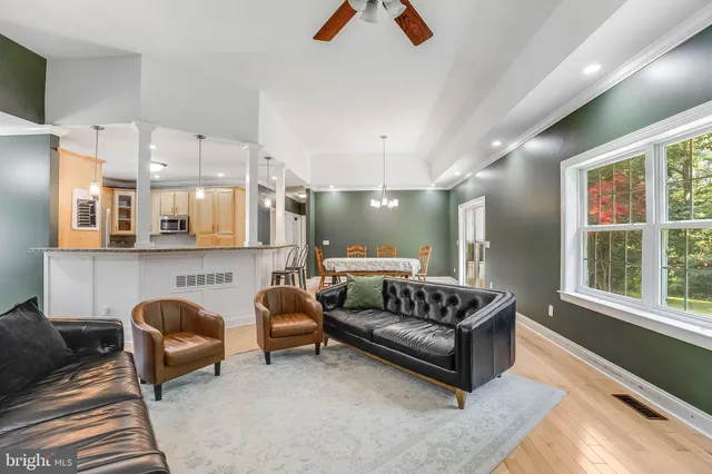 a living room with furniture ceiling fan and a window