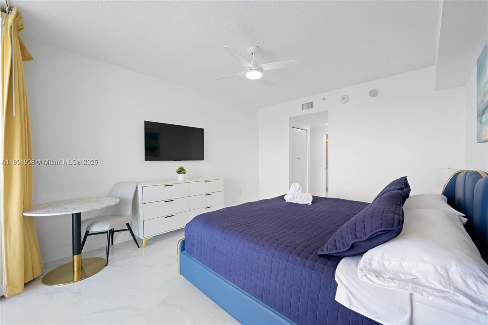 18100 North Bay Road, Unit 708 Sunny Isles Beach, FL 33160 - Photo 13 of 26 a spacious bedroom with a bed and a flat screen tv