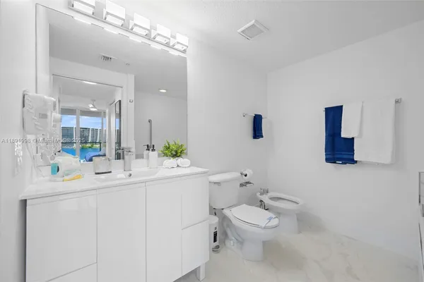 a bathroom with a toilet sink and mirror