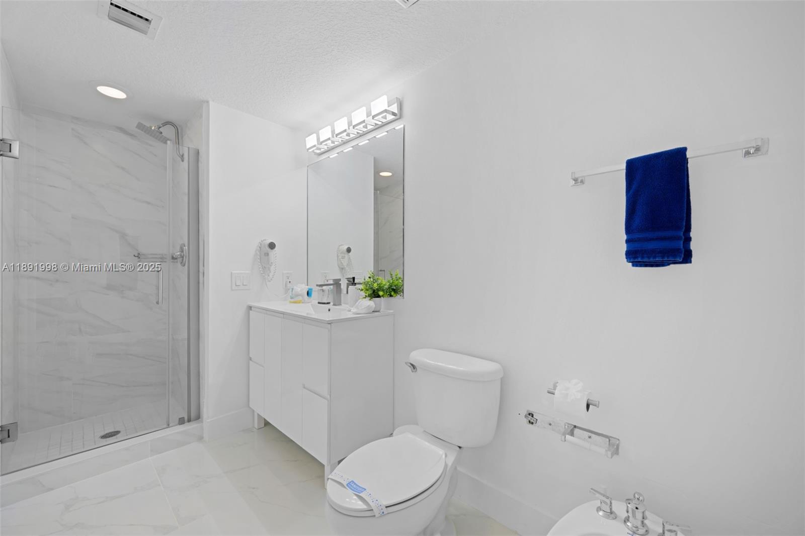 18100 North Bay Road, Unit 708 Sunny Isles Beach, FL 33160 - Photo 16 of 26 a bathroom with a toilet a sink and shower