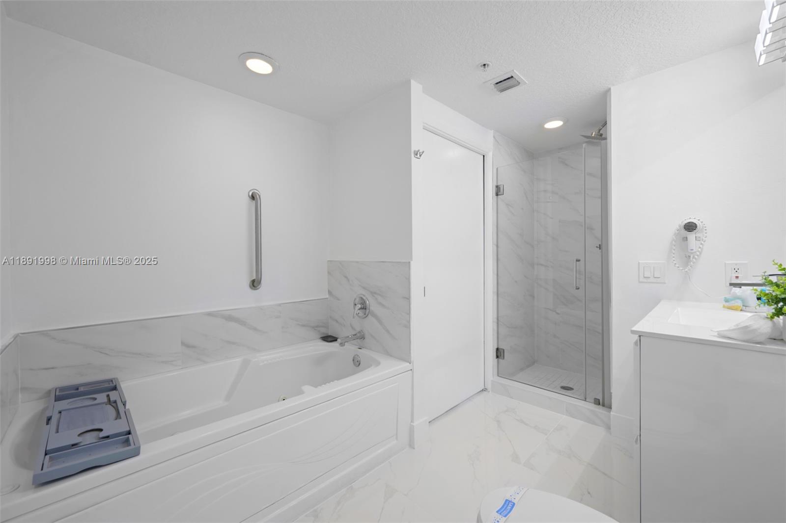 18100 North Bay Road, Unit 708 Sunny Isles Beach, FL 33160 - Photo 17 of 26 a bathroom with a bathtub and a shower
