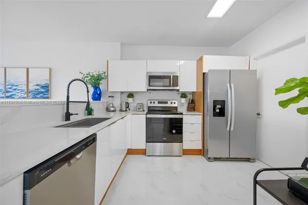 a kitchen with stainless steel appliances a refrigerator sink and stove