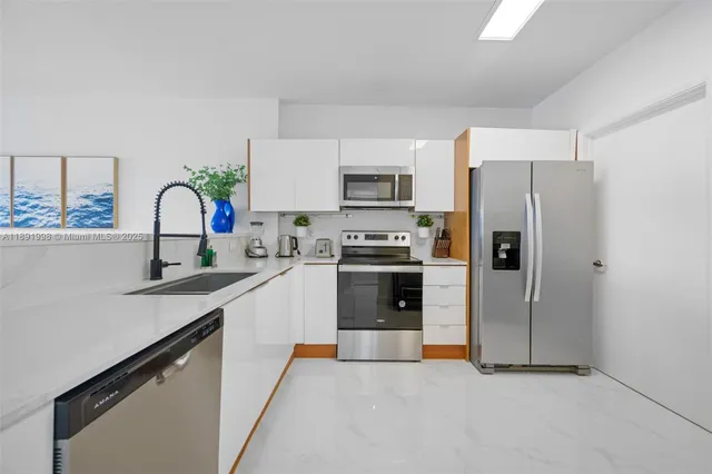a kitchen with stainless steel appliances granite countertop a refrigerator sink and stove