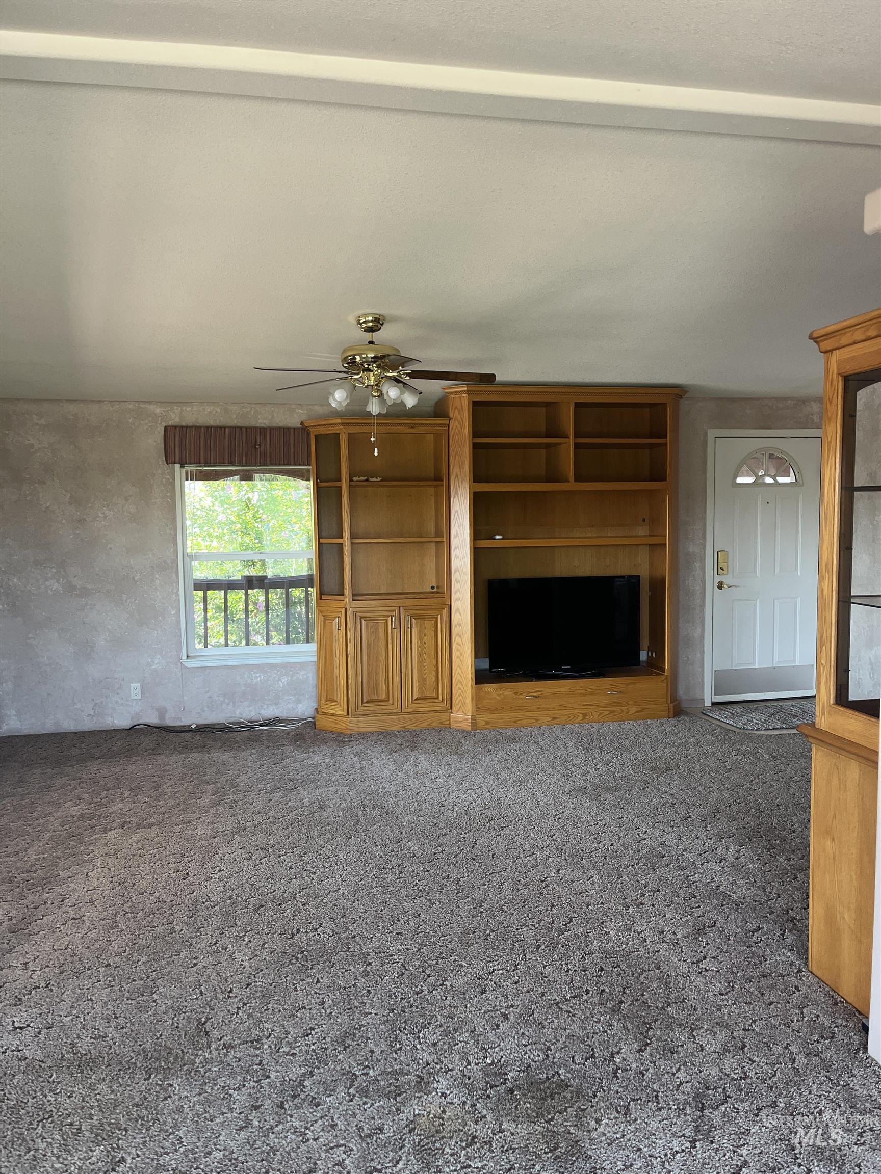 2750 Alden Road, Unit 34 Fruitland, ID 83619 - Photo 16 of 41 Unfurnished living room with dark carpet and a ceiling fan