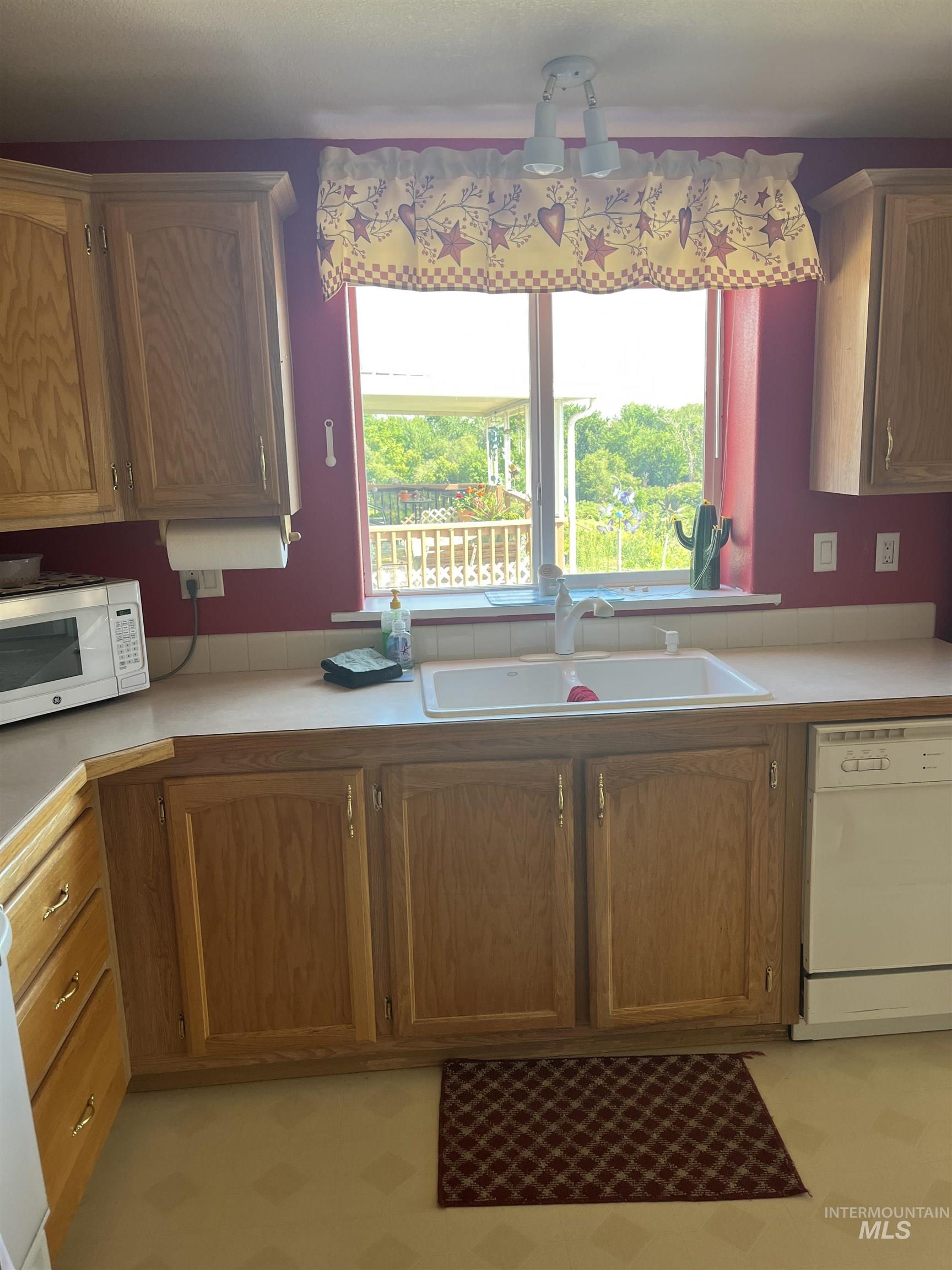 2750 Alden Road, Unit 34 Fruitland, ID 83619 - Photo 22 of 41 Kitchen with light countertops, white appliances, healthy amount of natural light, and brown cabinetry