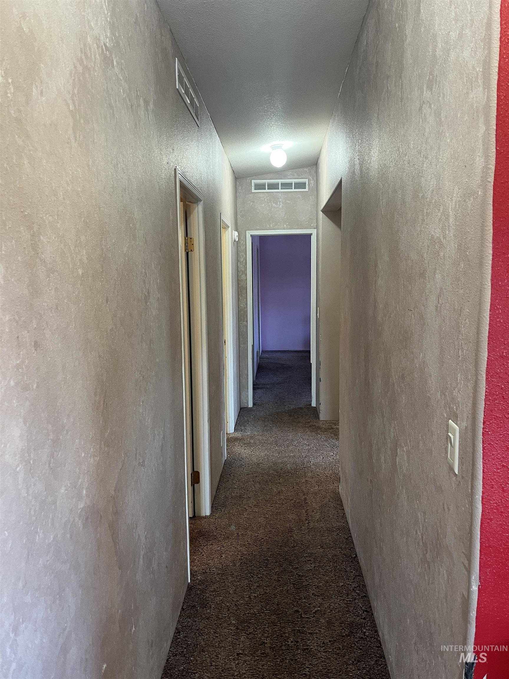 2750 Alden Road, Unit 34 Fruitland, ID 83619 - Photo 27 of 41 Hallway featuring dark carpet and a textured wall