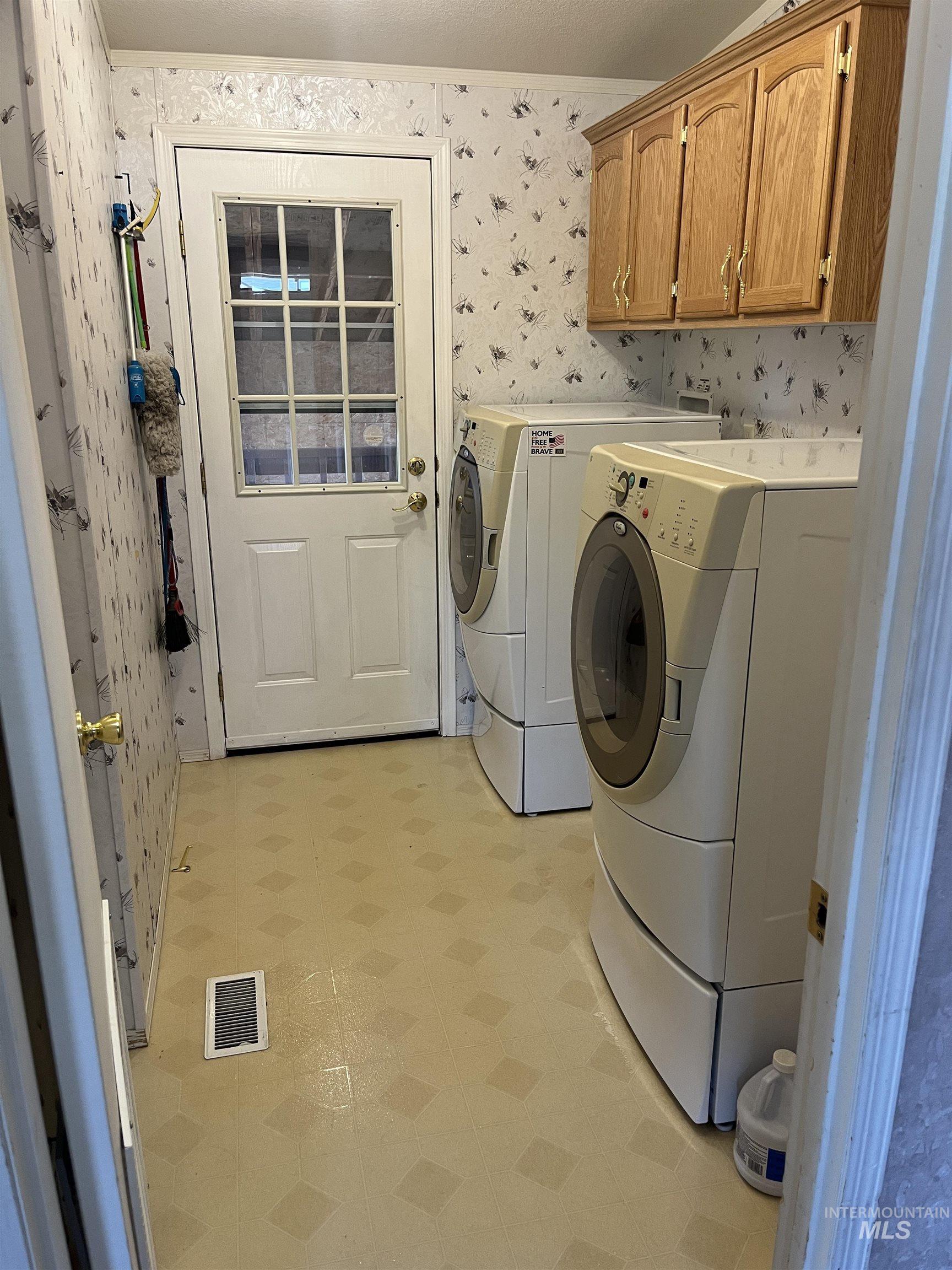 2750 Alden Road, Unit 34 Fruitland, ID 83619 - Photo 28 of 41 Washroom with wallpapered walls, washer and dryer, cabinet space, and light flooring