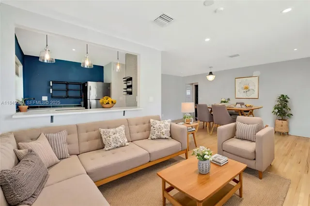 a living room with furniture and kitchen view