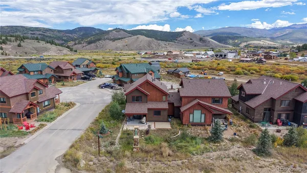 an aerial view of residential houses with outdoor space and ocean view