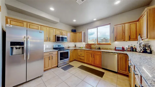 a kitchen with granite countertop stainless steel appliances a refrigerator sink and microwave