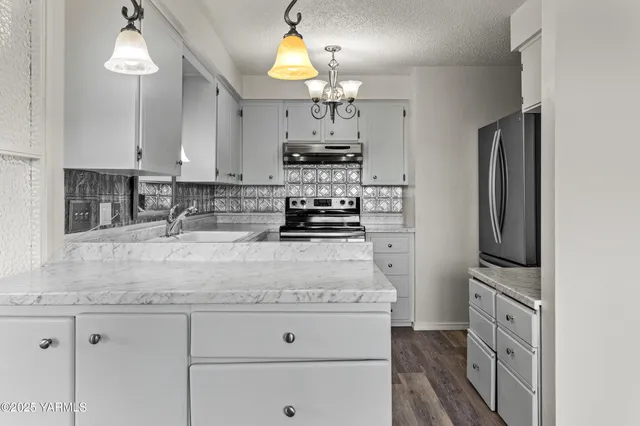 a kitchen with kitchen island granite countertop a stove cabinets and refrigerator
