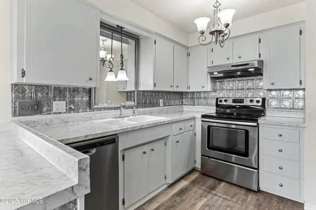 a kitchen with stainless steel appliances granite countertop a sink stove and microwave