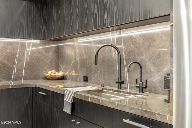 a kitchen with stainless steel appliances granite countertop a cabinets and a chandelier