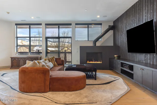 a living room with furniture and a floor to ceiling window