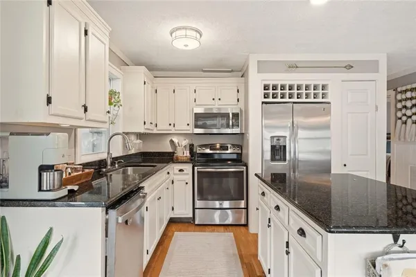 a kitchen with granite countertop a sink stove and refrigerator
