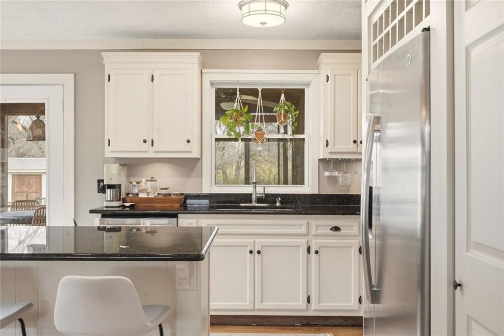 21 McIntosh Lane Rabun Gap, GA 30568 - Photo 18 of 53 a kitchen with granite countertop white cabinets and window
