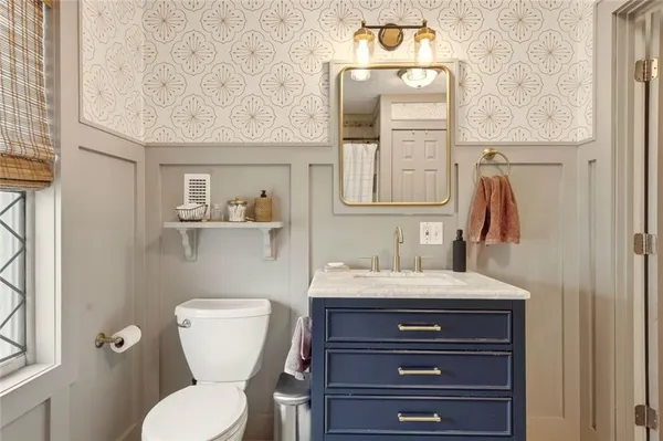a bathroom with a toilet sink and mirror