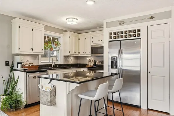 a kitchen with stainless steel appliances granite countertop a stove a sink and a refrigerator