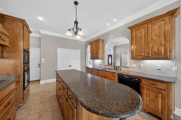 a large kitchen with kitchen island granite countertop a sink and a refrigerator
