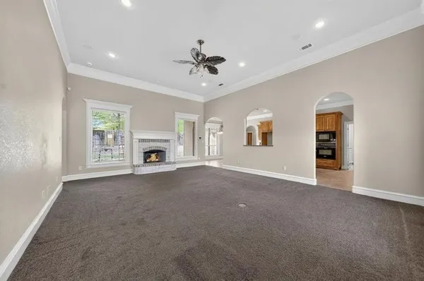 an empty room with fireplace and windows