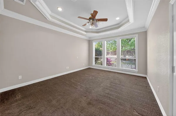 en empty room with windows and ceiling fan
