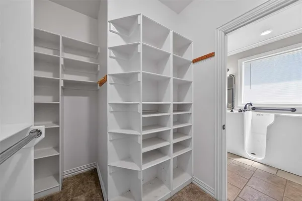 a view of walk in closet with empty racks