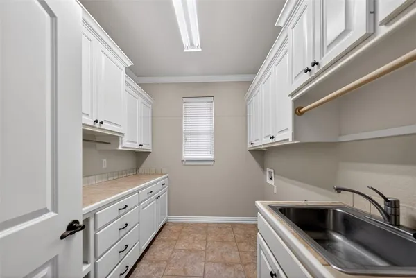 a kitchen with white cabinets and a sink
